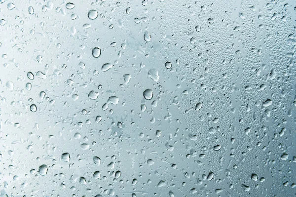 Teksturowanej tło okienka w oknie z tło zachmurzony. Wzór naturalnego od kropli deszczu na tło zachmurzony. — Zdjęcie stockowe