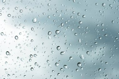 Bulutlu bir arka plan dokulu arka planını, pencere camı. Bir damla yağmur bulutlu bir arka plan üzerinde doğal desen.