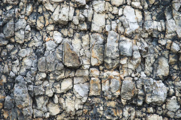 Pebble stones in a rocky wall. Natural background of a rocky stone wall — Stock Photo, Image