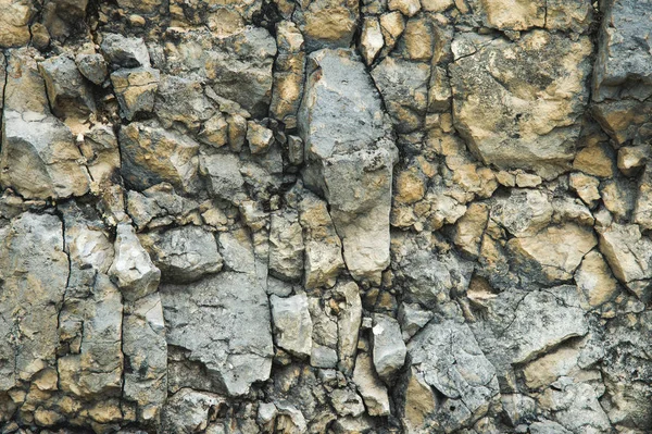 Bir kayalık duvar çakıl taşları. Kayalık bir taş duvar doğal arka plan