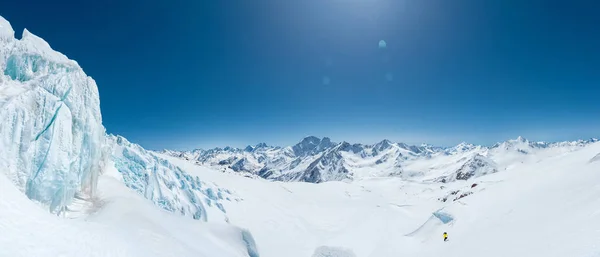 A neve de inverno cobriu picos de montanha no Cáucaso. Ótimo lugar para esportes de inverno. Alpinirst sobe colina acima com esquis . — Fotografia de Stock