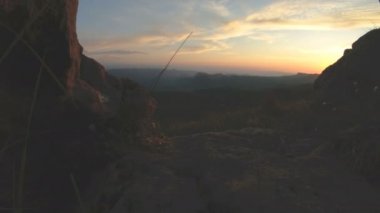 En yüksek kayanın üzerinde dağ günbatımı. Rock çimen Dağları paralaks anahtar günbatımı ışıkta karanlık kayalar