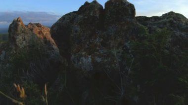 En yüksek kayanın üzerinde dağ günbatımı. Rock çimen Dağları paralaks anahtar günbatımı ışıkta karanlık kayalar