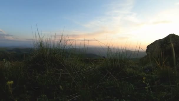 山ピークの岩に沈む夕日。山視差で暗い夕日ライト岩岩草 — ストック動画