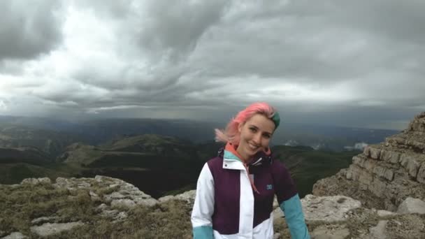 Girl young woman dances on the edge of a cliff of a plateau having fun nature mountains flowers beautiful attractive playing cheerful satisfied joy leisure funny laughing smile looking camera — Stock Video