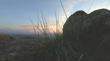 En yüksek kayanın üzerinde dağ günbatımı. Rock çimen Dağları paralaks anahtar günbatımı ışıkta karanlık kayalar
