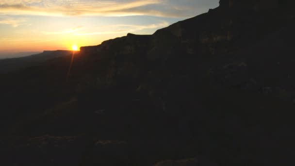 Mountain sunset over the peak rock. Dark key sunset light in the mountains parallax rocks rock grass — Stock Video