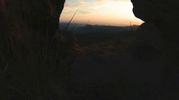 Puesta de sol de montaña sobre la roca pico. Luz oscura puesta del sol en las montañas paralaje rocas hierba de roca — Vídeo de stock