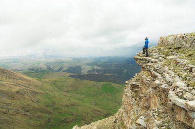 bir rock kenarında duran ve destansı bir plato üzerinde mesafe içine bakan sakallı hippi turist adam. Turizm kavramı