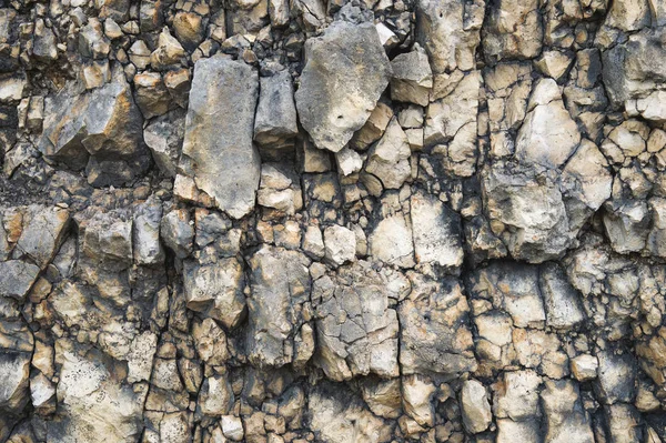 Bir kayalık duvar çakıl taşları. Kayalık bir taş duvar doğal arka plan