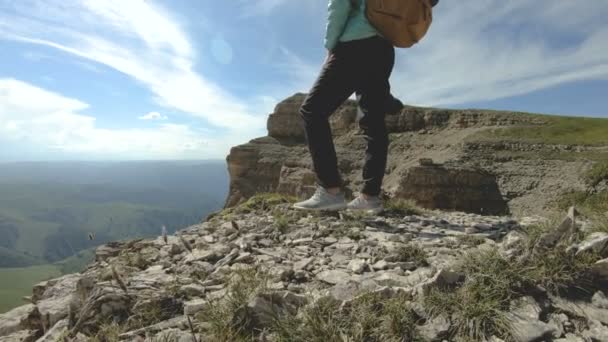 Een close-up van de poten van de meisjes van een fotograaf met een dslr camera in haar handen staat op een rotsachtig plateau op de achtergrond van een epische aard van de Kaukasische slowmotion 4k — Stockvideo