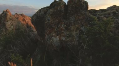 En yüksek kayanın üzerinde dağ günbatımı. Rock çimen Dağları paralaks anahtar günbatımı ışıkta karanlık kayalar