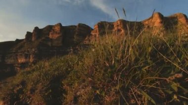 En yüksek kayanın üzerinde dağ günbatımı. Rock çimen Dağları paralaks anahtar günbatımı ışıkta karanlık kayalar