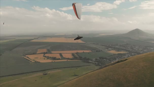 Atlet kluzáku létá na jeho kluzáku vedle vlaštovky. Pokračování natáčení z dron — Stock video