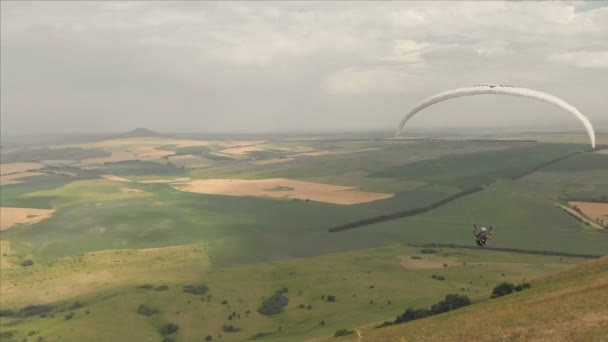 运动员滑翔伞飞行在他的滑翔伞旁边的燕子。无人机的后续拍摄 — 图库视频影像