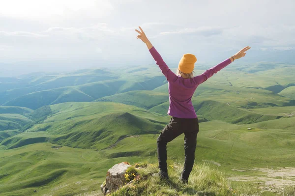 Young woman feeling strong and confident on the outdoor against green valley — Stock Photo, Image