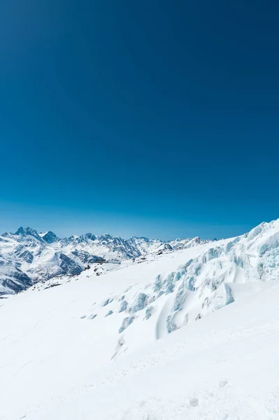 Picos de montaña cubiertos de nieve de invierno en el Cáucaso. Gran lugar para los deportes de invierno —  Fotos de Stock