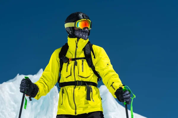 Bir yamaçta ayakta kayakçı. Biri hafif bir takım, kask ve maske içinde kayak kayak yapmak. Arka plan karla kaplı dağlara, kayakçı. Kafkas Dağları, Elbrus, Rusya Federasyonu — Stok fotoğraf