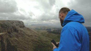 sakallı hippi adam Kafkasya dağlarında buzlu iken onun Smartphone cep telefonu ile fotoğraf çeker