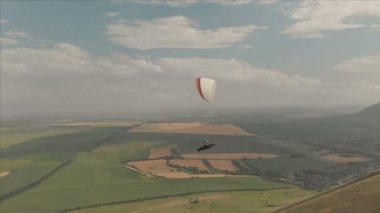 Atlet yamaçparaşütü yutar yanında onun paraglider üzerinde uçar. Drone çekim takip