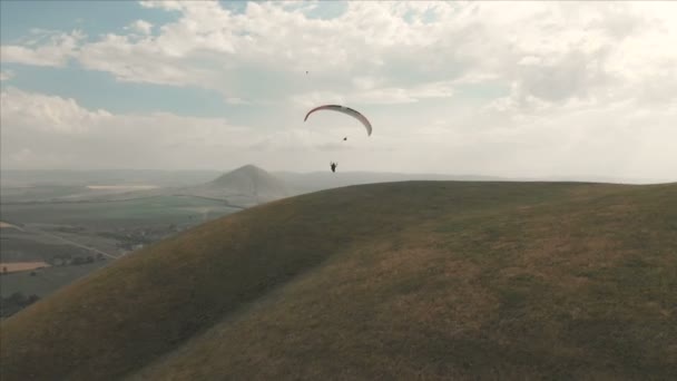 Idrottsman paraglider flugor på hans paraglider bredvid sväljer. Uppföljning skytte från drönaren — Stockvideo