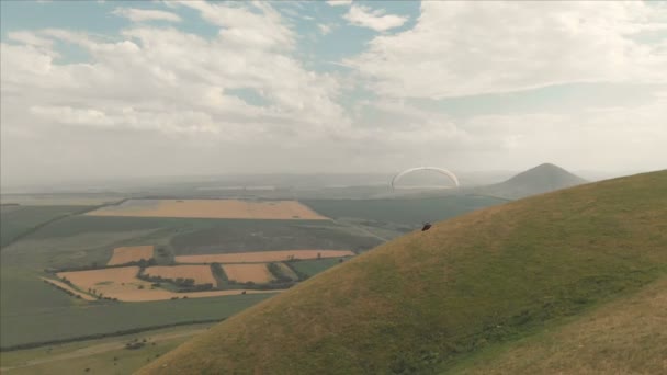 Atlet yamaçparaşütü yutar yanında onun paraglider üzerinde uçar. Drone çekim takip — Stok video