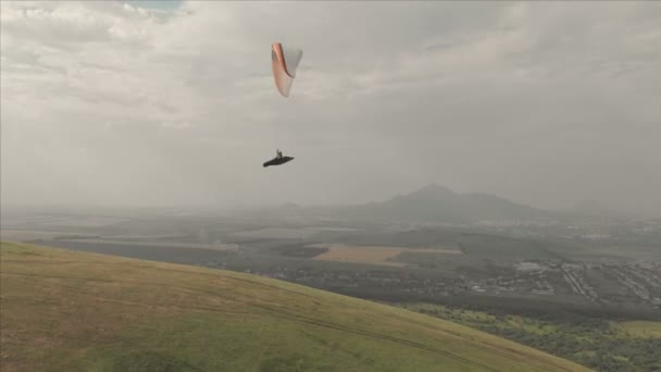 Parapente athlète vole sur son parapente à côté des hirondelles. Prise de vue de suivi depuis le drone — Video