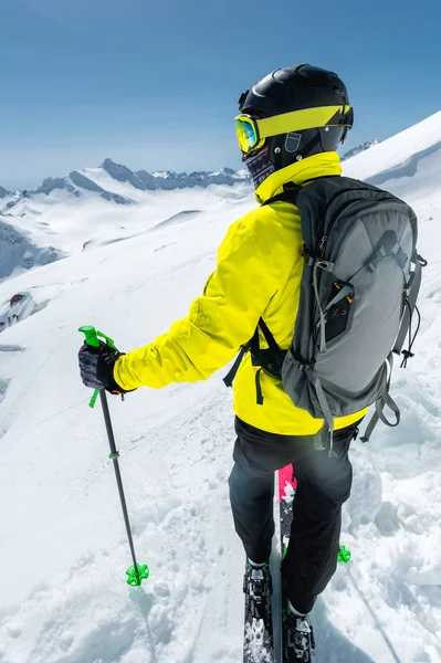 Ένας σκιέρ freerider σε πλήρη στολή στέκεται σε έναν παγετώνα στον Βόρειο Καύκασο φόντο τα χιονισμένα βουνά του Καυκάσου. Ευρεία γωνία — Φωτογραφία Αρχείου