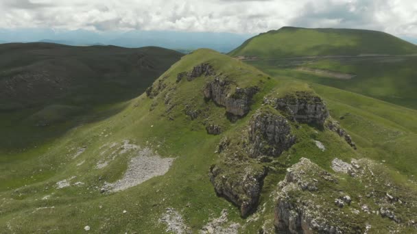 Volando sobre una gran formación rocosa entre los campos verdes. Rusia. Cáucaso Norte Vídeo del dron — Vídeos de Stock
