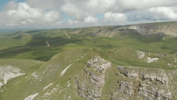 Yeşil alanlar arasında büyük kaya oluşumu etrafında uçan. Rusya. Kuzey Kafkasya — Stok video