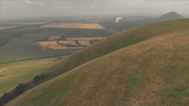 Atlet yamaçparaşütü yutar yanında onun paraglider üzerinde uçar. Drone çekim takip — Stok video