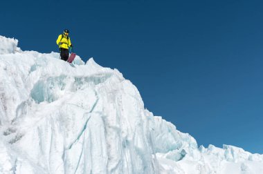 Tam kıyafeti freerider kayakçı Kuzey Kafkasya'da bir buzulun üzerinde duruyor. Kayakçı buzul atlama önce hazırlama