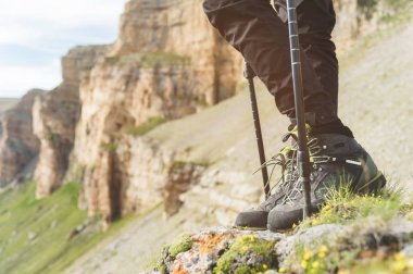Trekking botları Nordic walking kayalar ve uzak Kafkas topraklarda arka planı için sopa ile kadın bacakları Close-Up.
