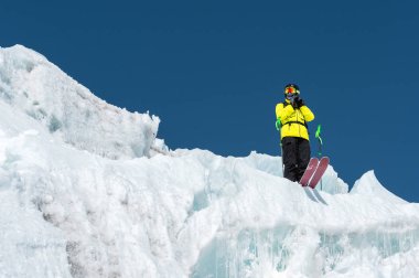 Tam kıyafeti freerider kayakçı Kuzey Kafkasya'da bir buzulun üzerinde duruyor. Kayakçı buzul atlama önce hazırlama