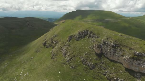 Volando alrededor de una gran formación rocosa entre los campos verdes. Rusia. Cáucaso Norte — Vídeos de Stock