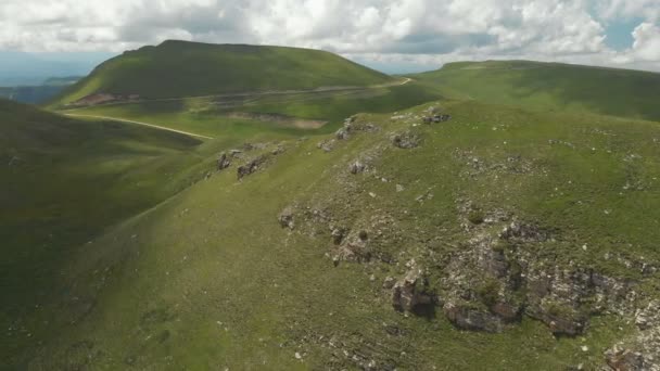Volando intorno ad una grande formazione rocciosa tra i campi verdi. Russia. Caucaso settentrionale — Video Stock