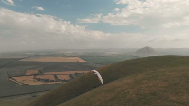Idrottsman paraglider flugor på hans paraglider bredvid sväljer. Uppföljning skytte från drönaren — Stockvideo