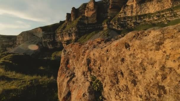 Günbatımı gökyüzü bulutlu bir kayalık vadide içinde düşük bir anahtar. Gün batımında rock massif dibinde arazi Panoraması. 4 k ılık ışık — Stok video