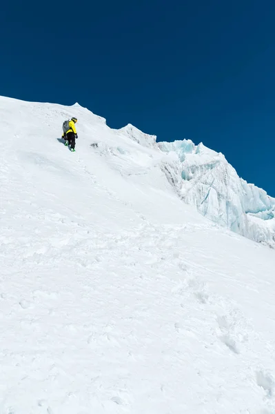 Uno sciatore in casco e maschera con uno zaino si erge su un pendio sullo sfondo di neve e un ghiacciaio. Backcountry Freeride — Foto Stock