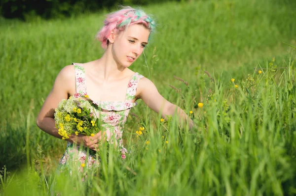 Retrato de uma jovem menina sorridente feliz em um vestido de algodão com um buquê de flores silvestres — Fotografia de Stock