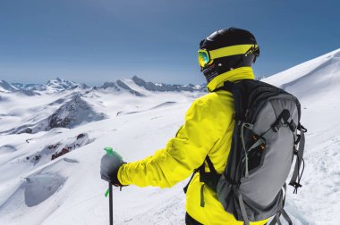Tam kıyafeti freerider kayakçı arka planı beyaz karla kaplı Dağları'nın Kuzey Kafkasya'da bir buzulun üzerinde duruyor. Geniş açı