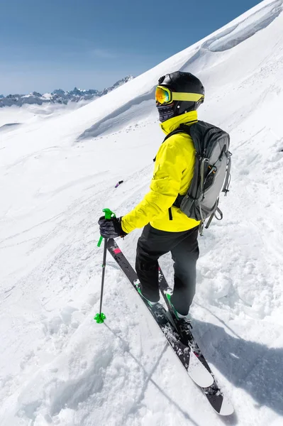 Een freerider skiër in volledige outfit staat op een gletsjer in de noordelijke Kaukasus tegen de achtergrond van de Kaukasische besneeuwde bergen. Groothoek — Stockfoto