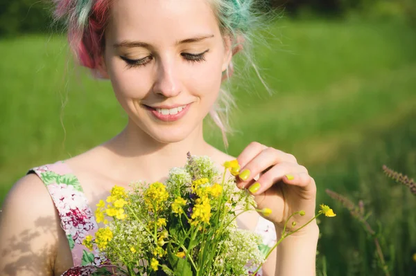 Retrato de uma jovem menina sorridente feliz em um vestido de algodão com um buquê de flores silvestres — Fotografia de Stock