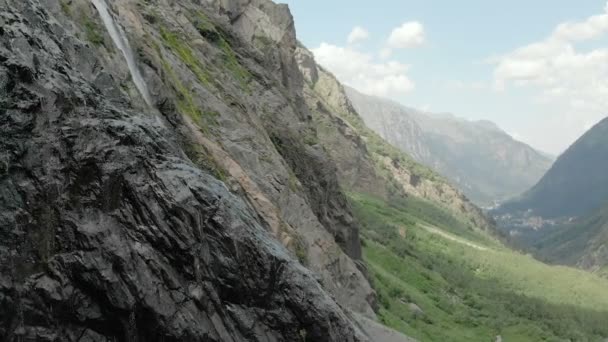 Kamerafahrten und Luftaufnahmen aus einem Wasserlauf, der an einer Felswand im Kaukasus plätschert. um den Strahl des Wasserfalls — Stockvideo