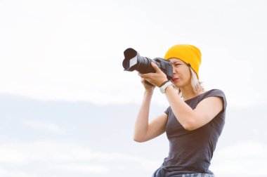 Açık havada profesyonel bir fotoğrafçı portresi. Bir kız fotoğrafçı onu kamera onu kameraya çekiyor. Trevors fotoğraf