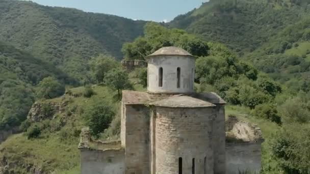 Kalkış dağda yüksek duran eski harap Hıristiyan Kilisesi çevresinde kabuklarıyla kapatın. Erial görünümü. Kuzey Kafkasya. Rusya — Stok video