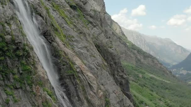 Bijhouden en top shot lucht geschoten uit een stroom van water nat van de waterval op een rotswand in de bergen van de Kaukasus. Rond de straal van de waterval — Stockvideo