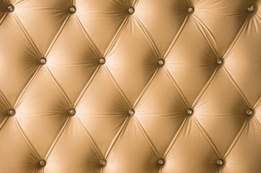 Elmas köşelerinde simetrik düğmeleri ile bej yumuşak Tekstil arka plan. Yumuşak ve pahalı mobilya parçaları. Lüks arka plan