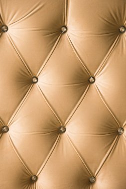 Elmas köşelerinde simetrik düğmeleri ile bej yumuşak Tekstil arka plan. Yumuşak ve pahalı mobilya parçaları. Lüks arka plan