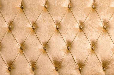 Elmas köşelerinde simetrik düğmeleri ile bej yumuşak Tekstil arka plan. Yumuşak ve pahalı mobilya parçaları. Lüks arka plan